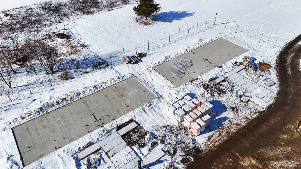 вид зверху на житловий комплекс у процесі будівництва з залитими фундаментами для prefab-будинків