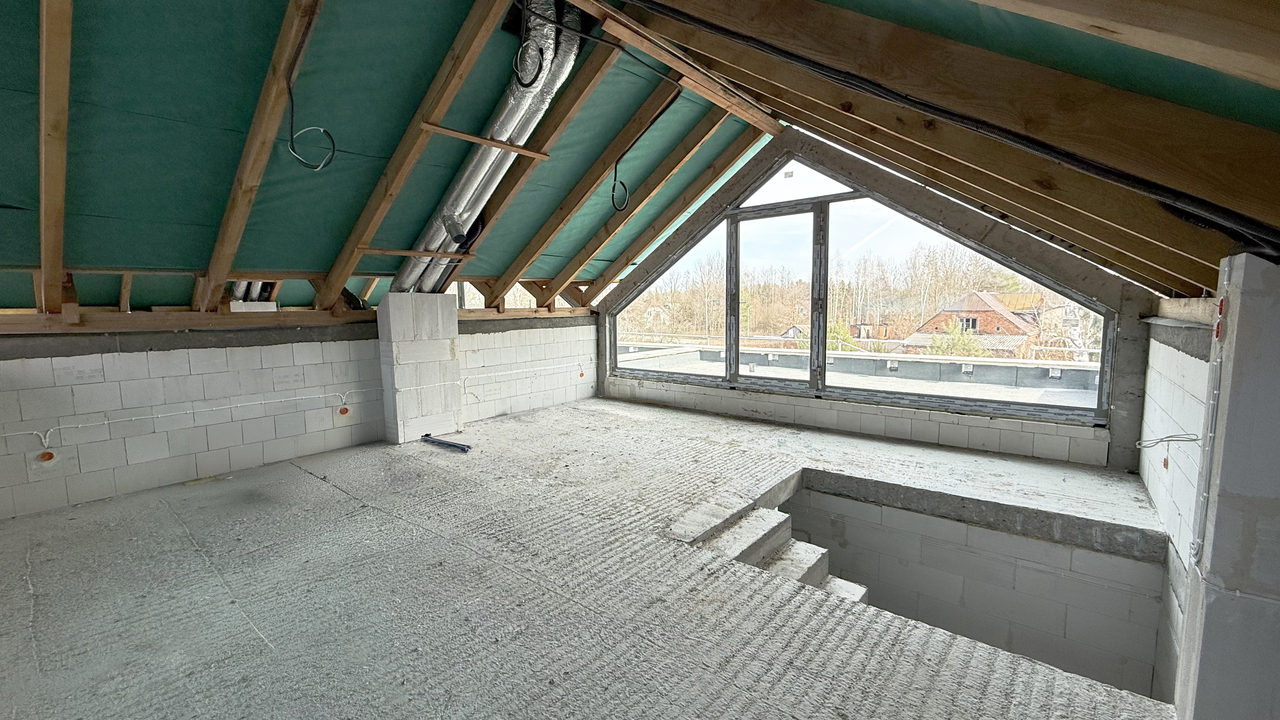 pokój na poddaszu z dużym oknem i wyjściem na taras na dachu