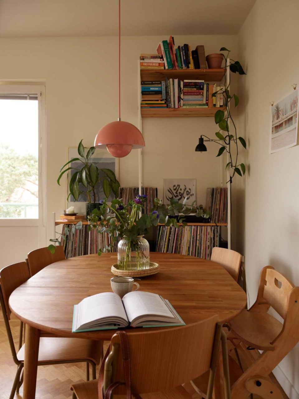 otwarta książka i kubek z herbatą stojące na drewnianym stole w salonie jako pokazanie trendu wnętrzarskiego 2026 lived-in interiors