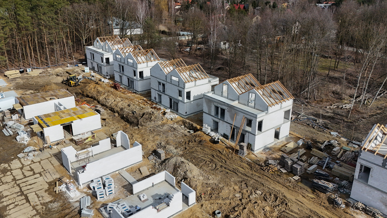 widok z góry na osiedle w trakcie budowy i budynki na różnych etapach budowy