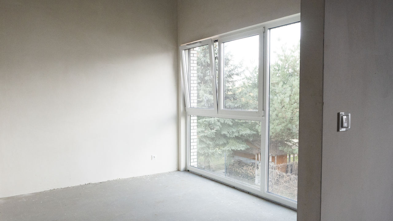 wnętrze pokoju i duże panoramiczne okno w domu na osiedlu miasto ogród