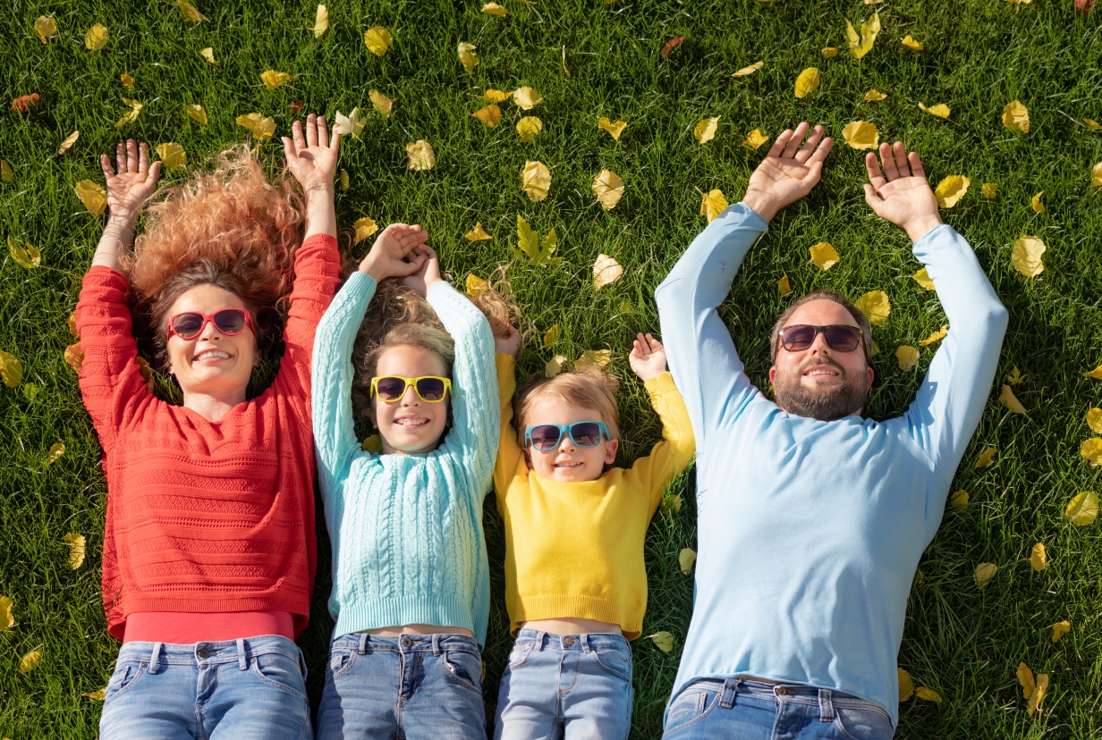 radosna rodzina leży na trawie we własnym ogródku obok domu