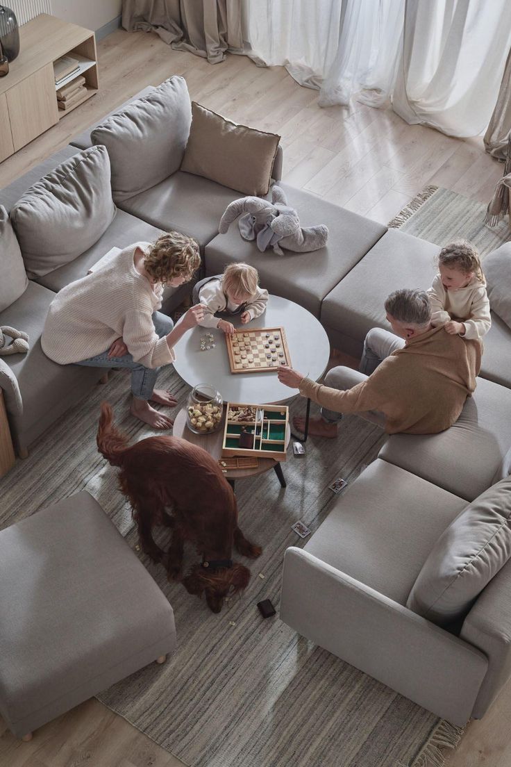 rodzina spędza czas w salonie w swoim nowym domu a obserwator patrzy z góry stojąc na schodach