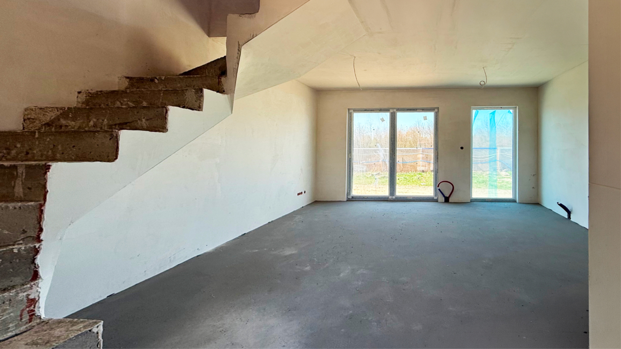 salon z wyjściem do ogrodu w domu deweloperskim 