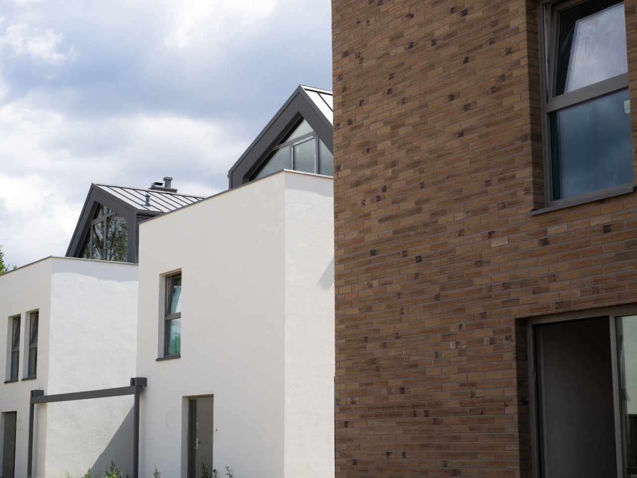 wyjątkowa i nowoczesna architektura domów jednorodzinnych na osiedlu Wille przy Lesie przeszklone poddasze z tarasem i elewacja imitująca cegłę