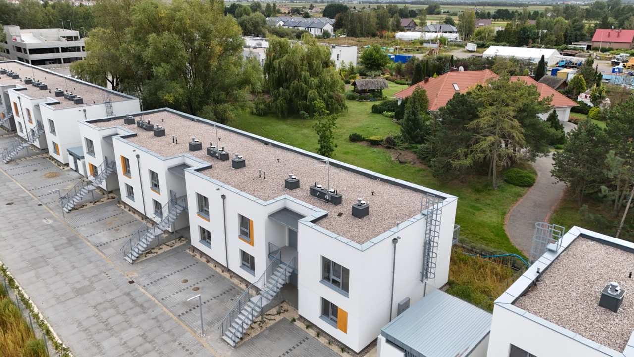 widok z góry na budynki szeregowe na Osiedlu Młodych i otaczająca niska zabudowa jednorodzinna