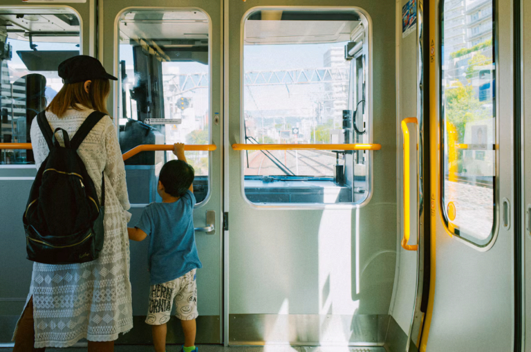 mama z synkiem stoi w tramwaju przy poręczach